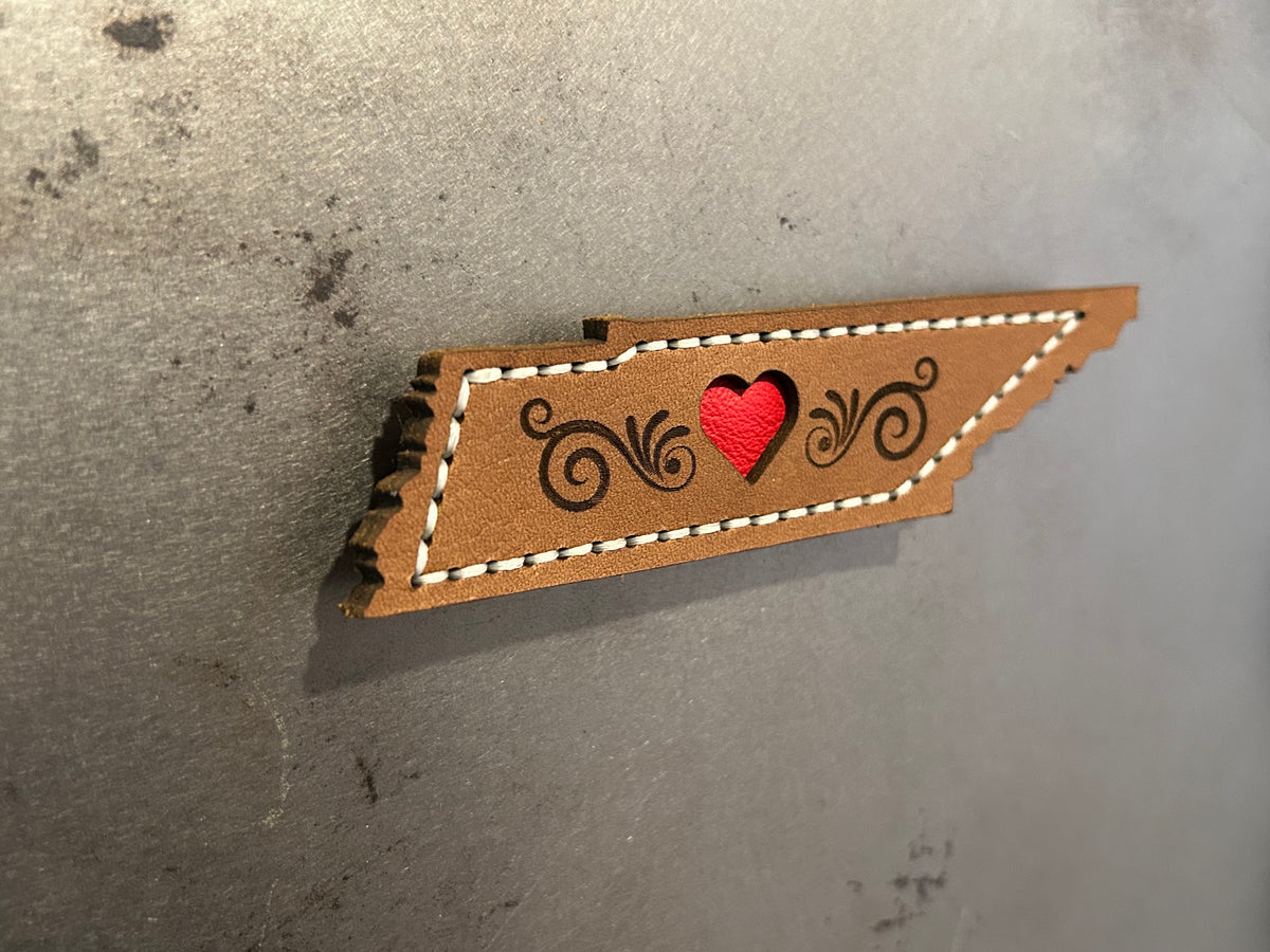 A Tennessee-shaped leather magnet with a red heart made by Hutton Forge. 