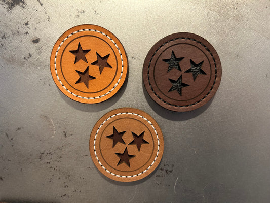 Three hand-stitched brown leather magnets featuring the Tennessee Tri-Star design with cut-out stars, shown in different stitching colors. Hutton Forge.