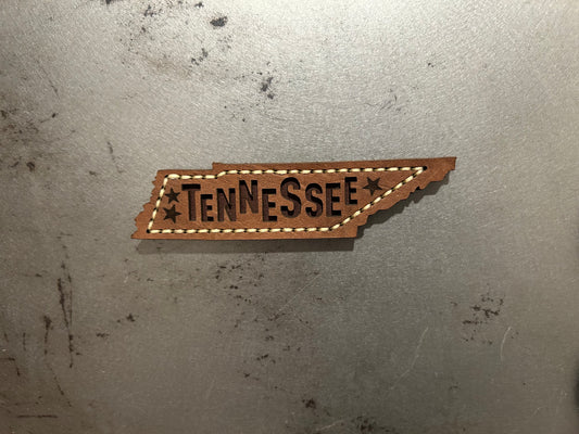 A Tennessee-shaped leather patch with 'TENNESSEE' text and star details made by Hutton Forge. 