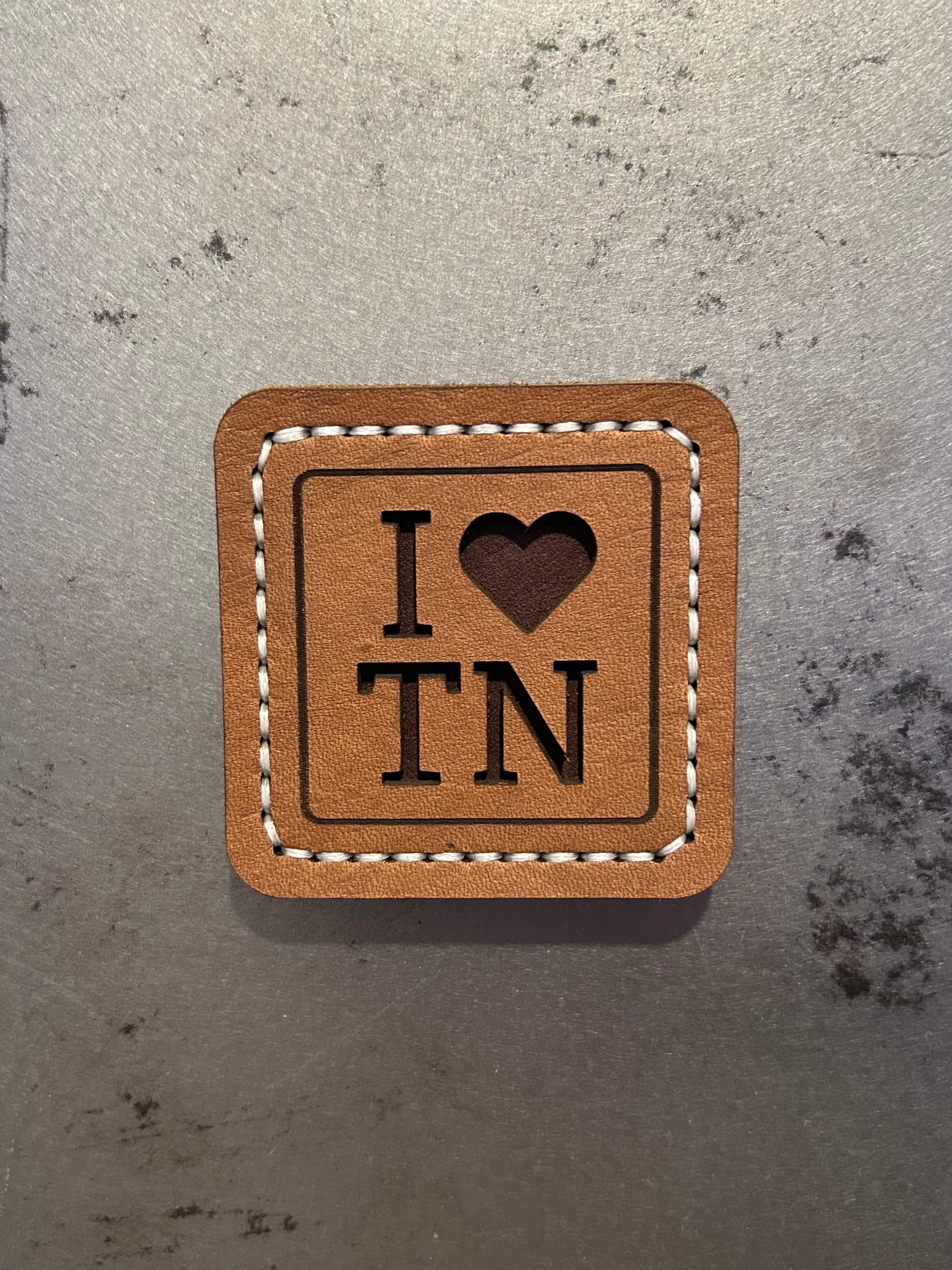 Hand-stitched brown leather magnet with an “I Love TN” design, handmade by Hutton Forge.
