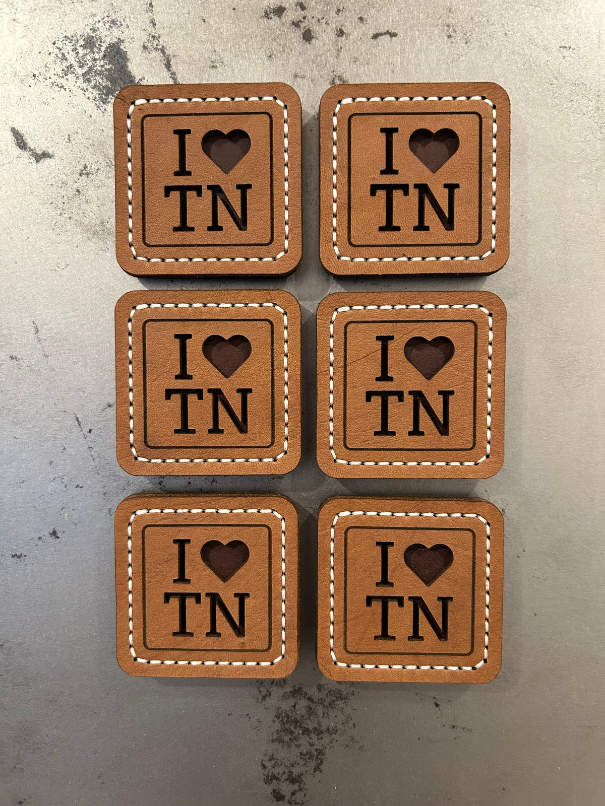 Hand-stitched brown leather magnets with an “I Love TN” design, handmade by Hutton Forge.