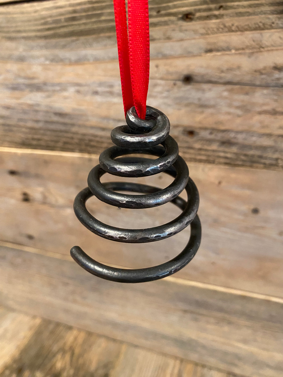Unique blacksmith spiral Christmas tree ornament hanging on a Christmas Tree. Hutton Forge