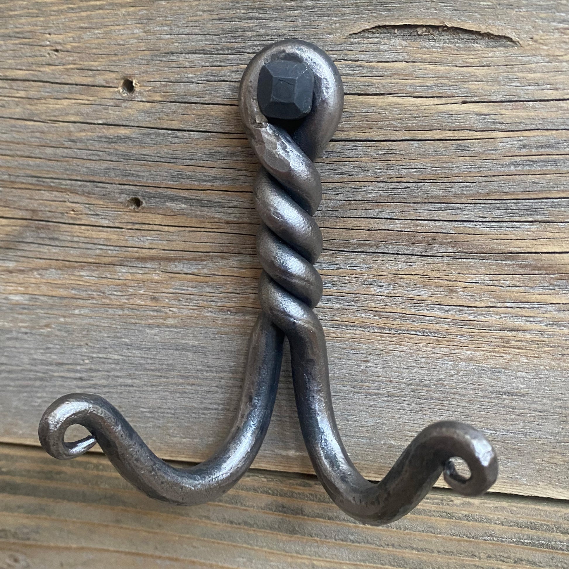Decorative metal wall hook on a wooden background