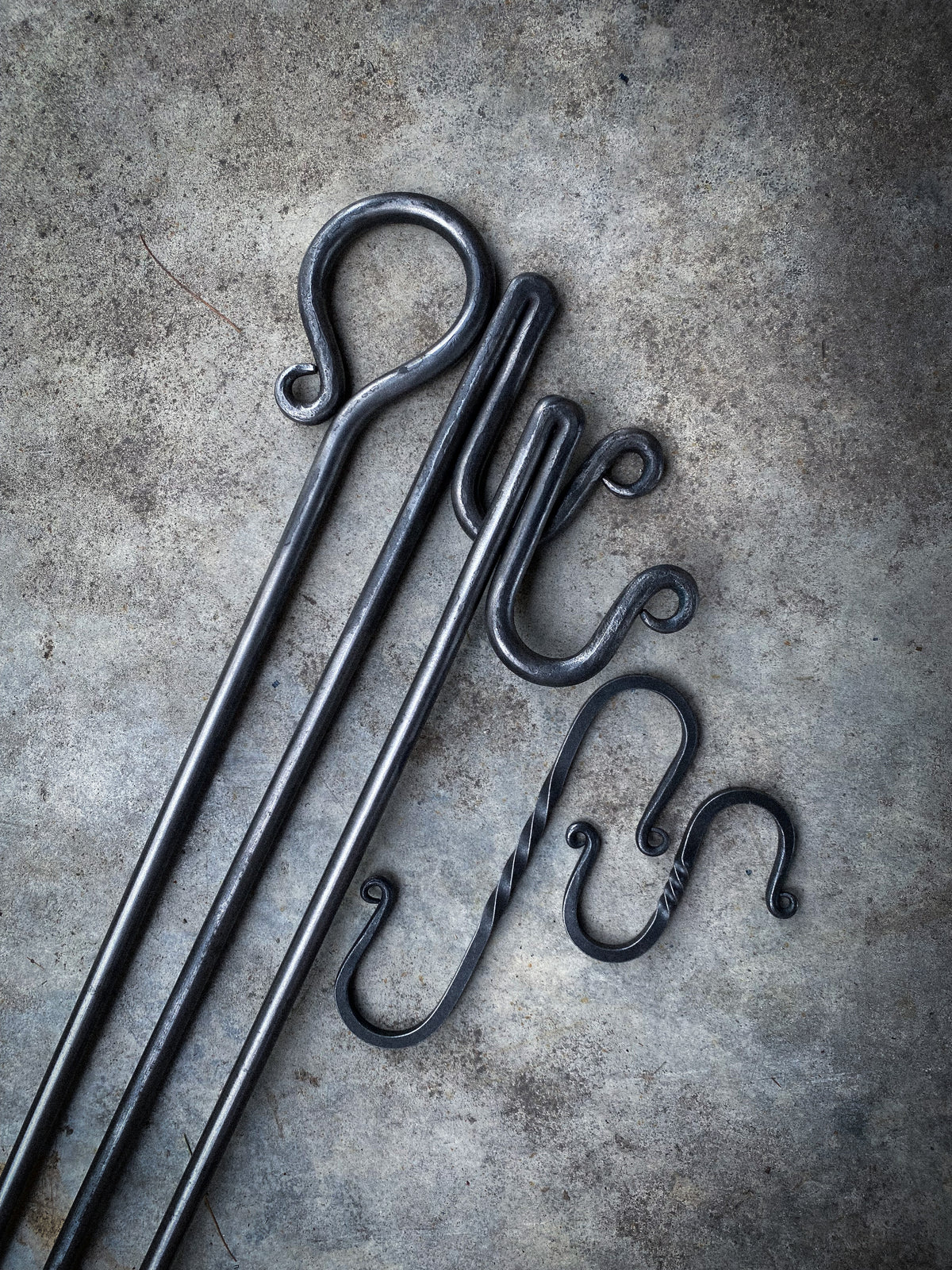 Hand-forged round steel campfire cooking tripod with 2 S hooks. Hutton Forge.
