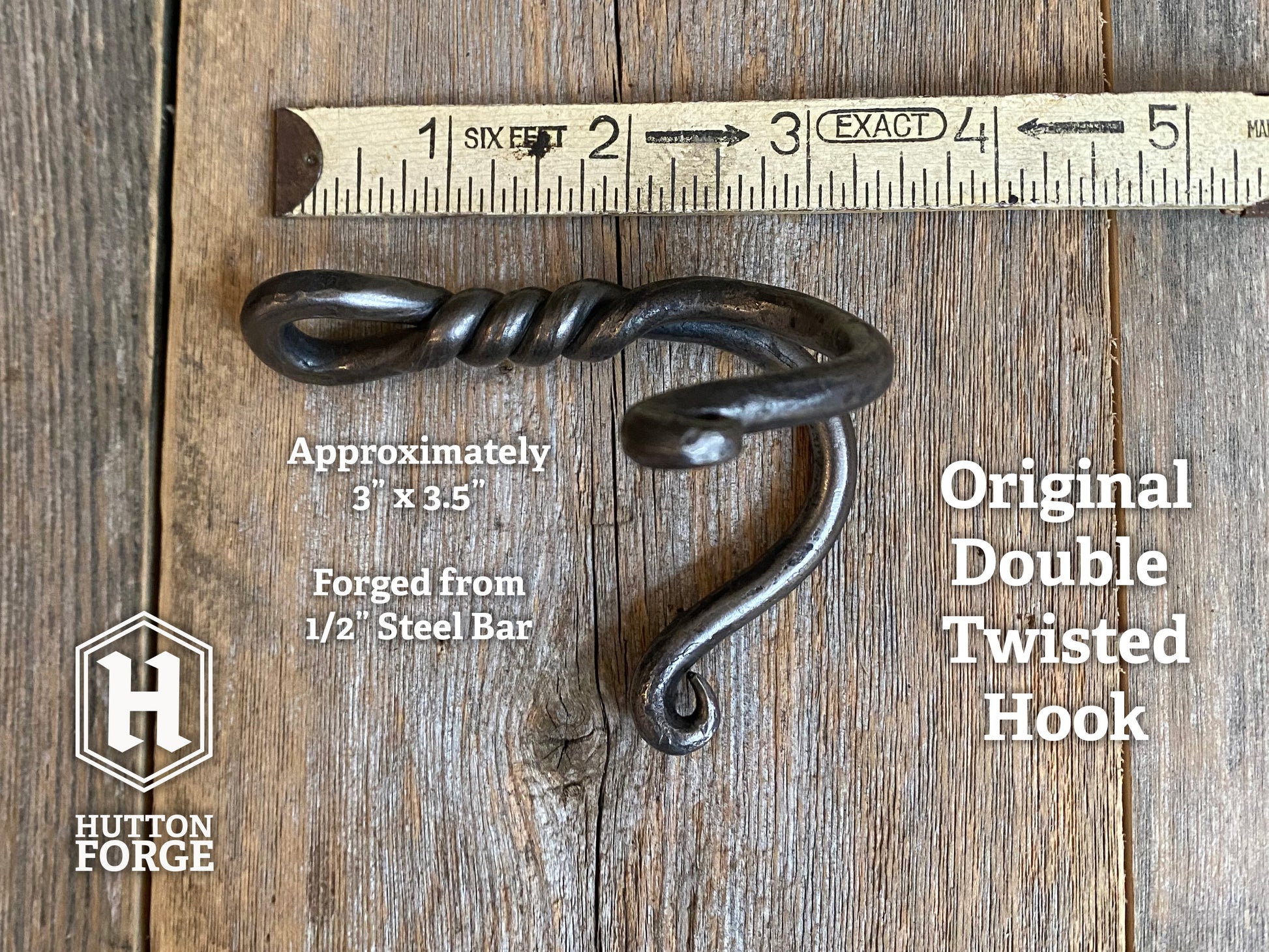 Wrought iron hook on a wooden surface with a ruler for scale, featuring Hutton Forge branding.