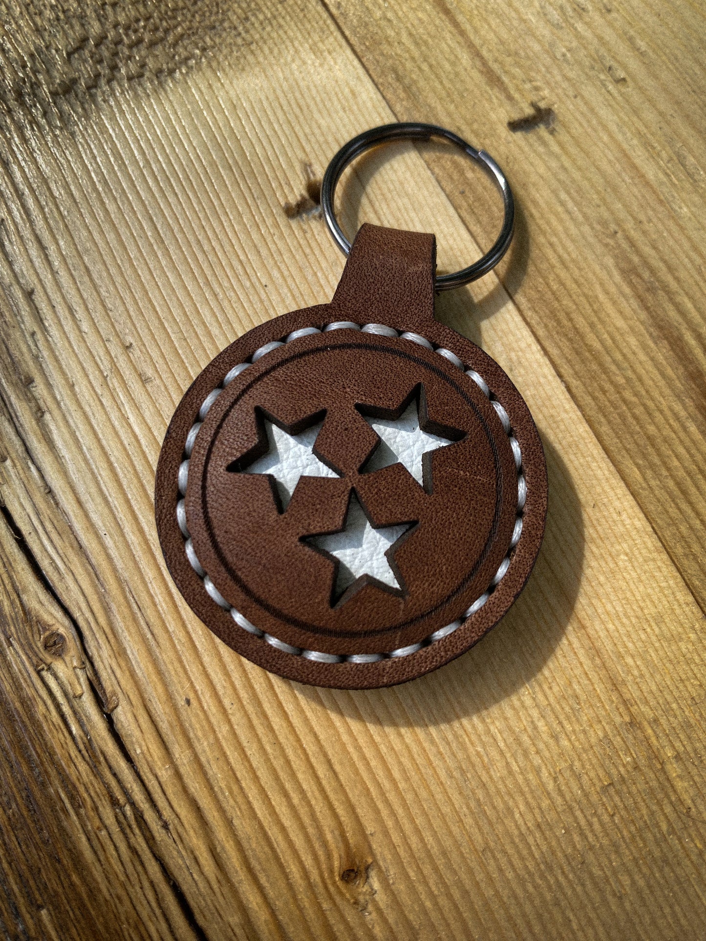 Hand-stitched keychain featuring the Tennessee Tri-Star design with cut-out stars, shown in white stitching.  Hutton Forge.
