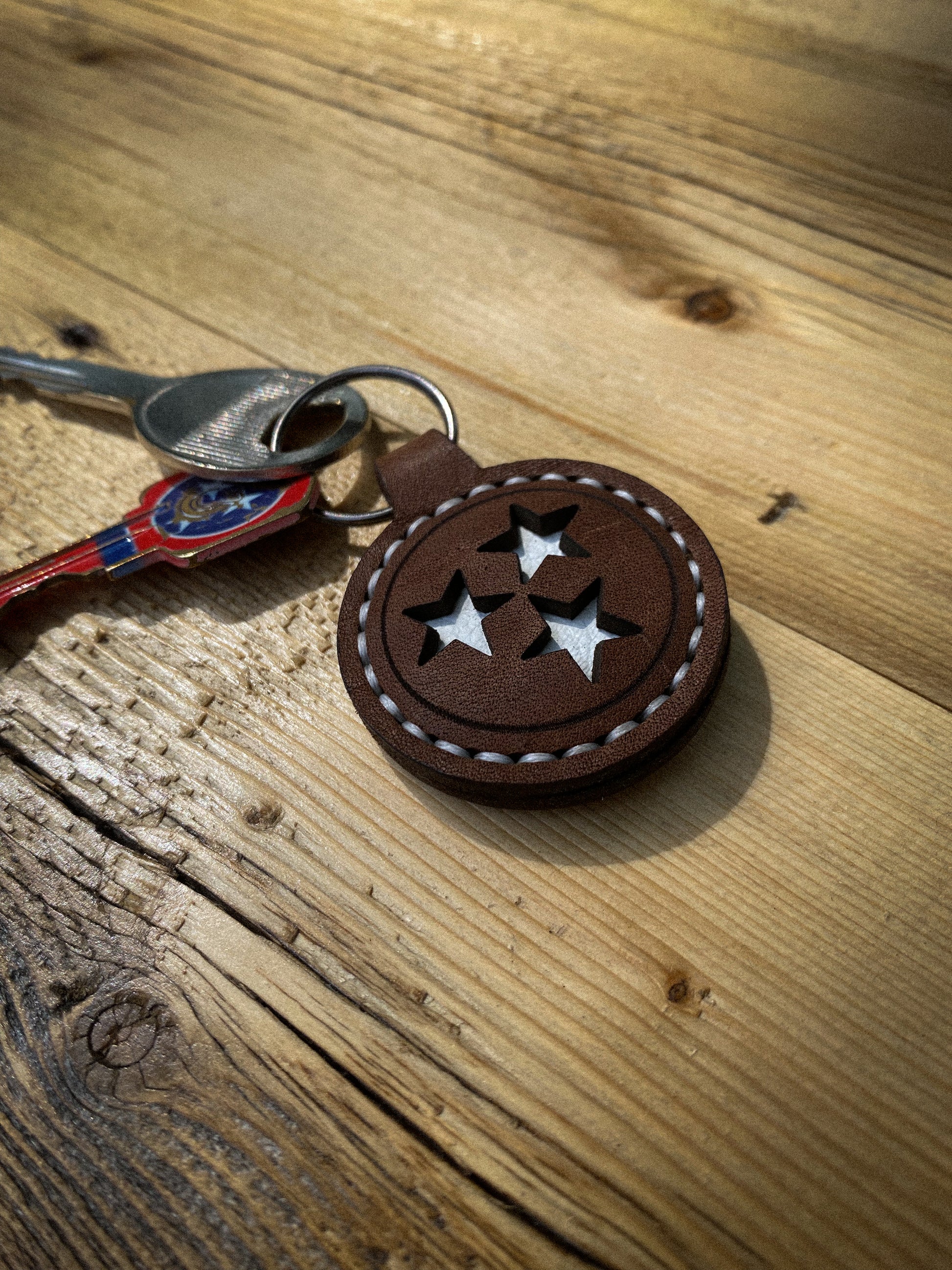 Hand-stitched keychain featuring the Tennessee Tri-Star design with cut-out stars, shown in white stitching with keys attached.  Hutton Forge.