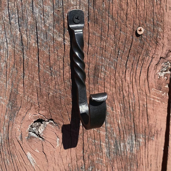 PersonHangingAHatOnASteelHook